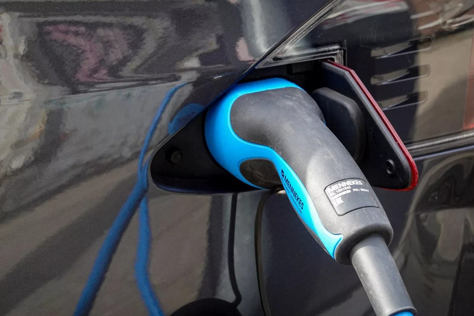 Elektrikli aracın şarj soketine tam oturmuş Type 2 konnektörün yakın plan görüntüsü